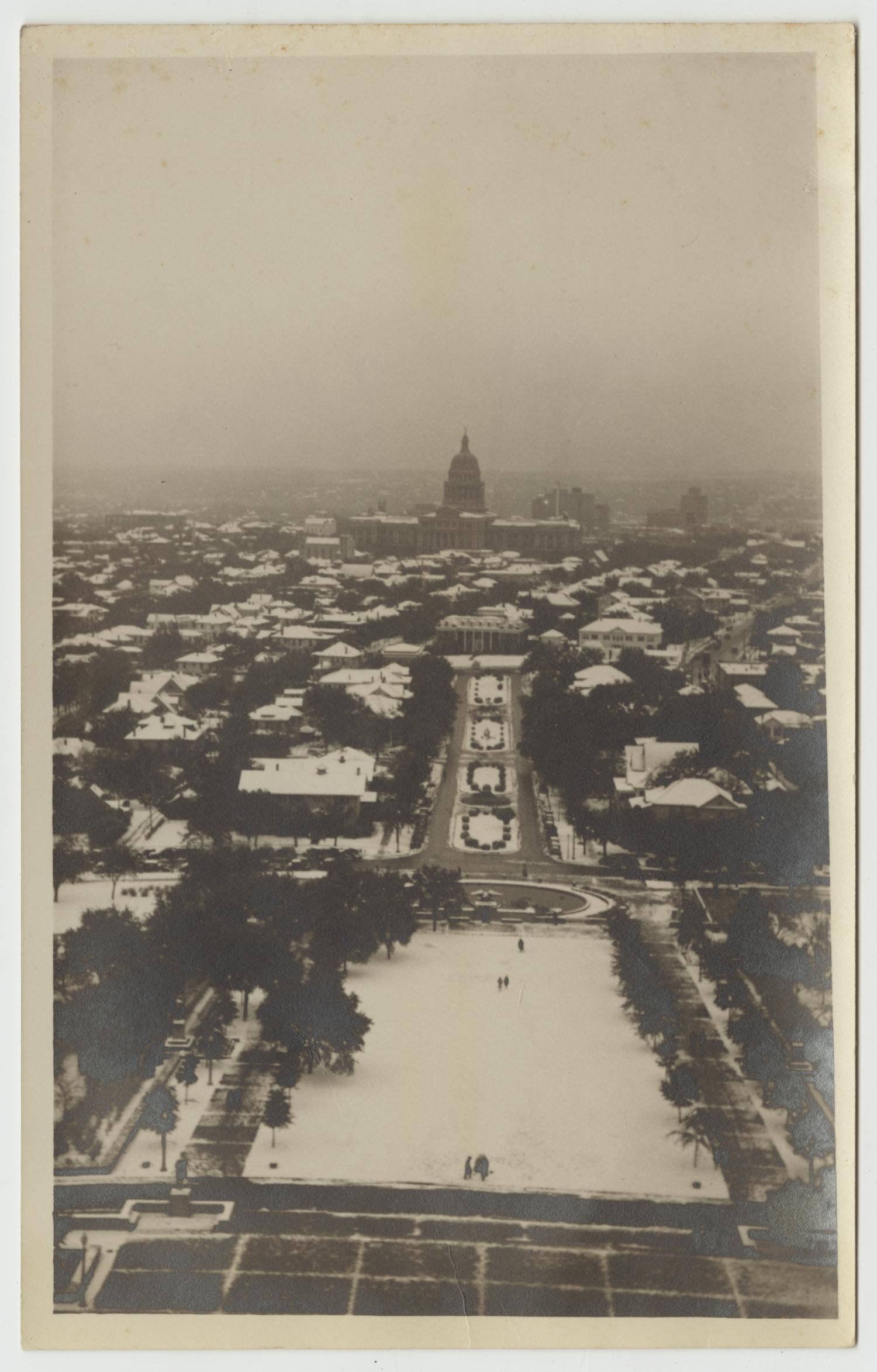 A black and white photograph of ice and snow of Austin including the university south mall and the state capitol building